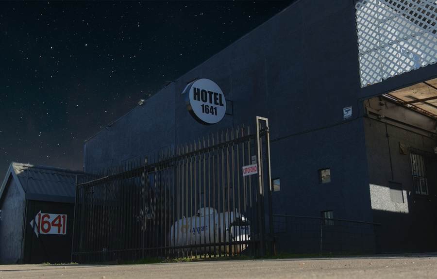 Frontis nocturno de Hotel 1641 con letrero iluminado y cielo estrellado