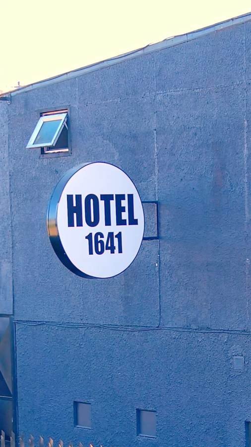 Letrero circular de Hotel 1641 sobre fachada azul