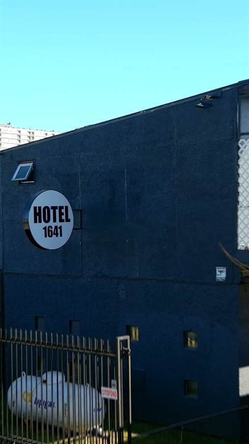 Fachada de Hotel 1641 de día, vista amplia con reja de acceso
