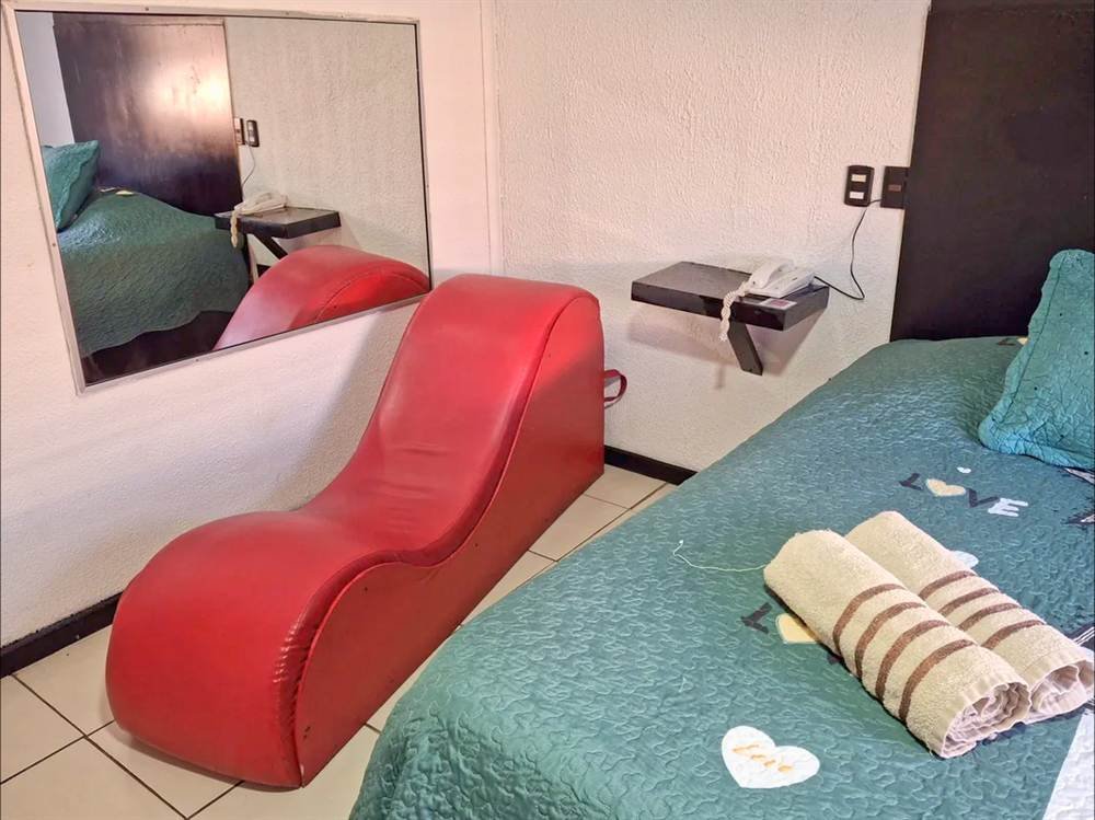 Habitación Tántrica de Hotel 1641 con Sillón del Amor rojo, cama y espejo